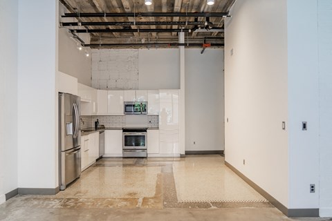 a kitchen with white cabinets and a stainless steel refrigerator