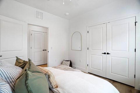 A bedroom with a bed and a mirror on the wall.