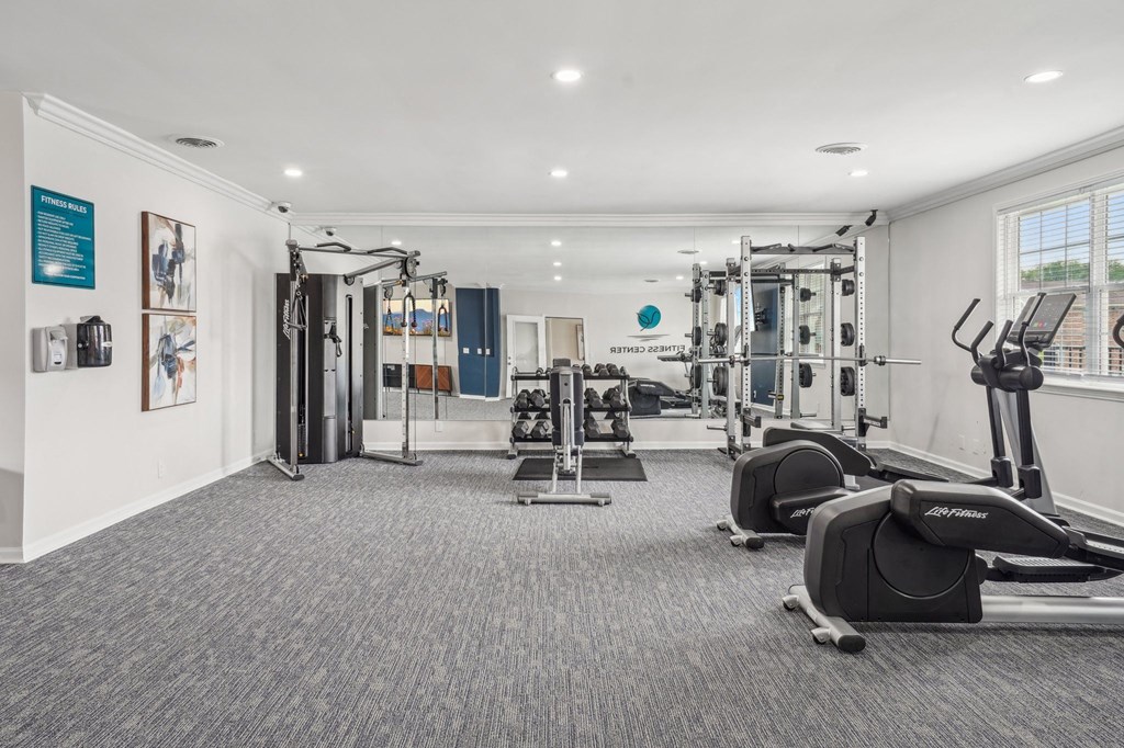 Well-equipped fitness center with weight machines, free weights, and elliptical trainers.