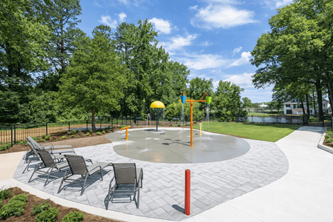 Outdoor splash pad and seating area at Somerset Apartments in Charlotte, NC, perfect for residents of studio, 1, 2, and 3 bedroom apartments