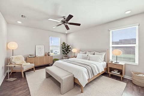 A bedroom with a large bed, a chair, and a ceiling fan.