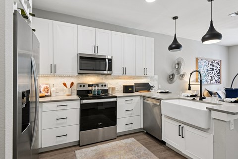 A modern kitchen with white cabinets and stainless steel appliances.