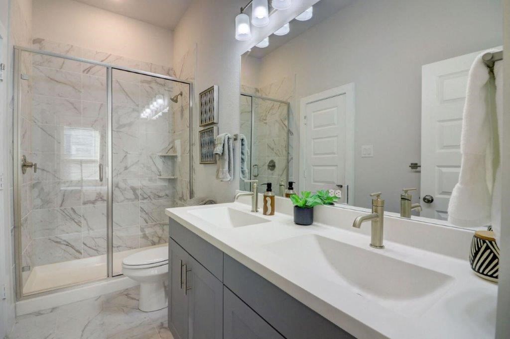 a bathroom with a sink and a shower and a toilet