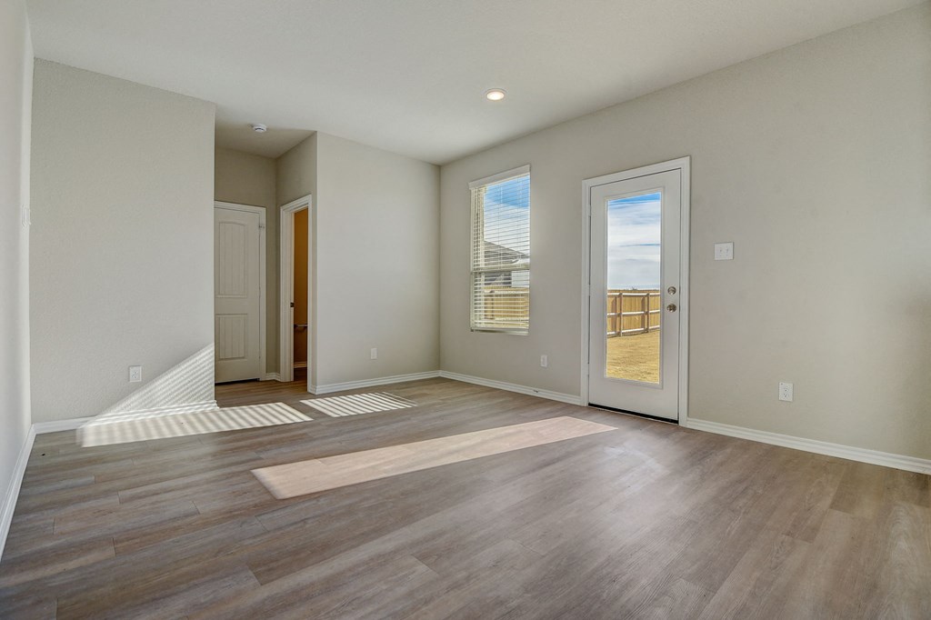 an empty living room with a door to a balcony