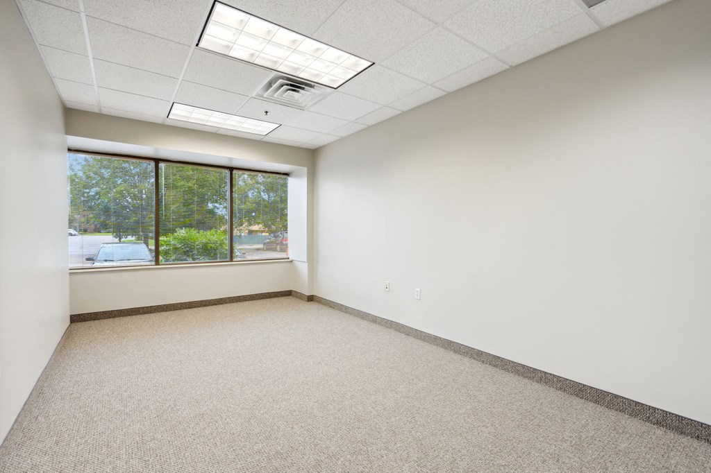 an empty room with a large window and white walls