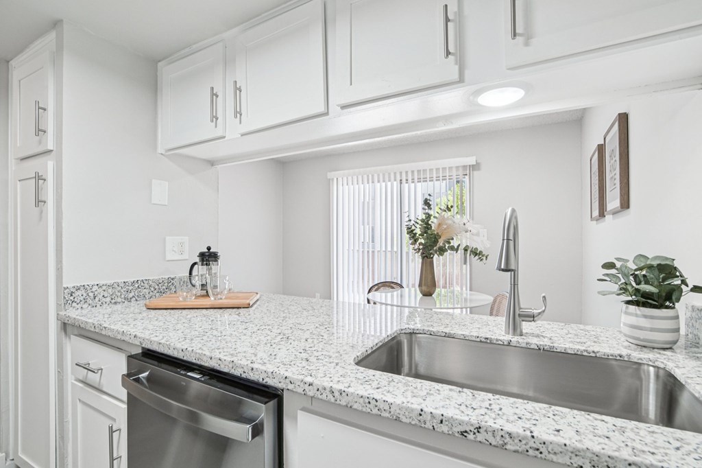 A kitchen with a granite countertop and stainless steel appliances.