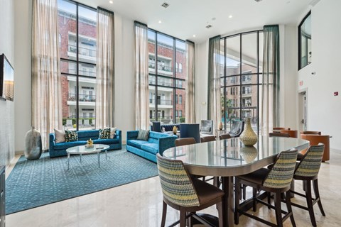 A modern living room with a glass table and blue couches.