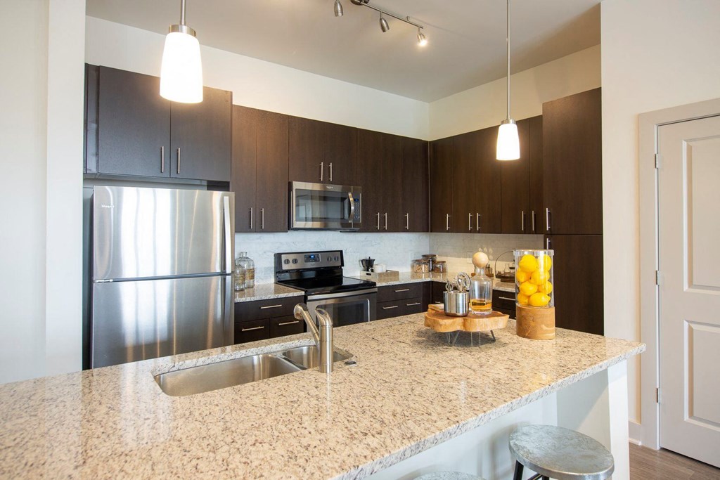 Atlanta Apartments - Arabelle Perimeter -Luxury kitchen with stainless steel appliances and a counter top