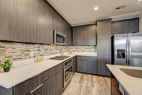A modern kitchen with dark wood cabinets and a stainless steel refrigerator.