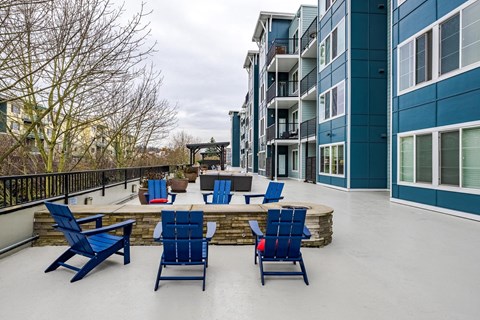 A patio with blue chairs and a table.