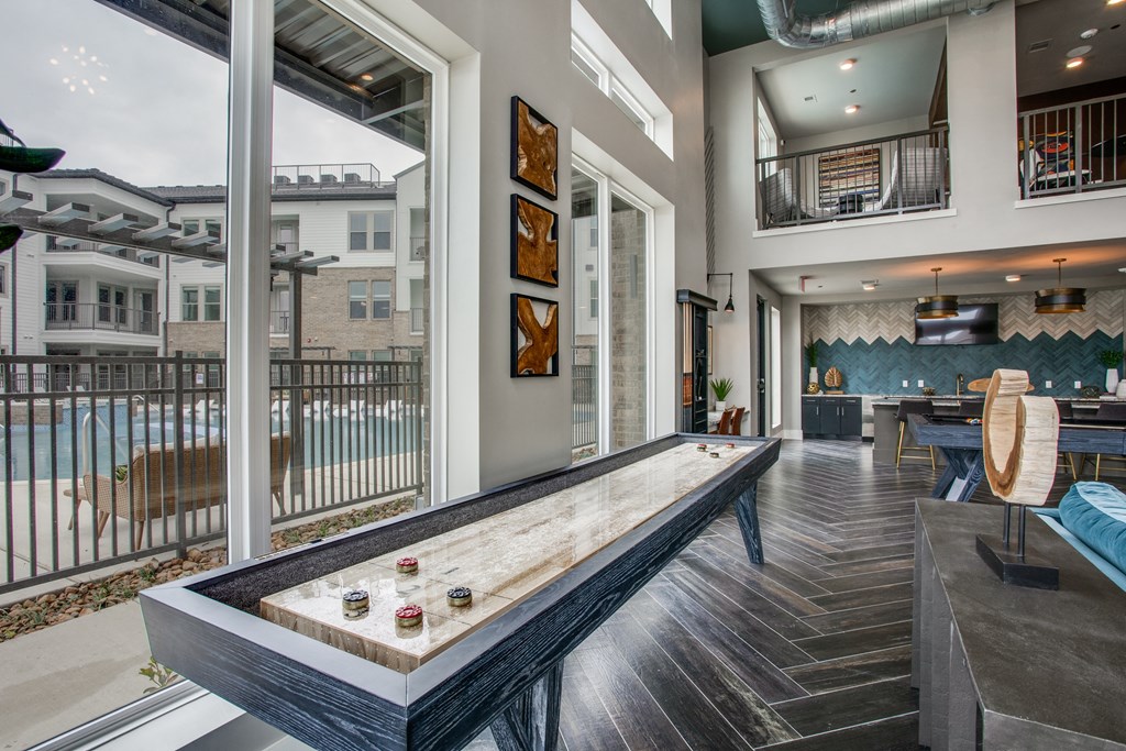 a games room with a shuffleboard table
