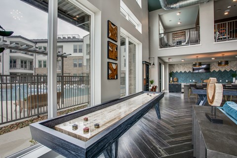 a games room with a shuffleboard table