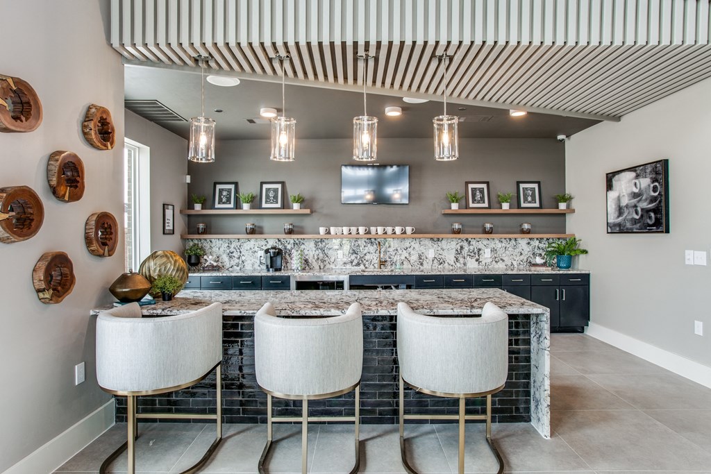 a kitchen with a large island with three stools in front of it