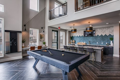 clubhouse with pool table and bar at the bradley braddock road station apartments