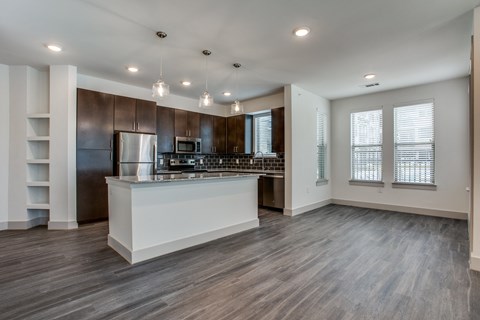 a kitchen and living room with hardwood floors and white walls