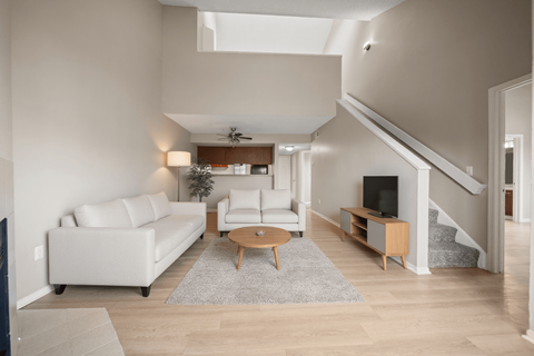 A living room with a white couch and a wooden coffee table.