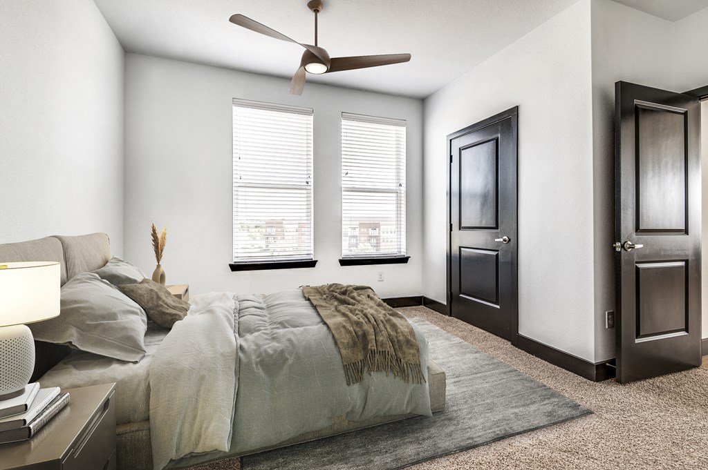 a bedroom with a large bed and a ceiling fan