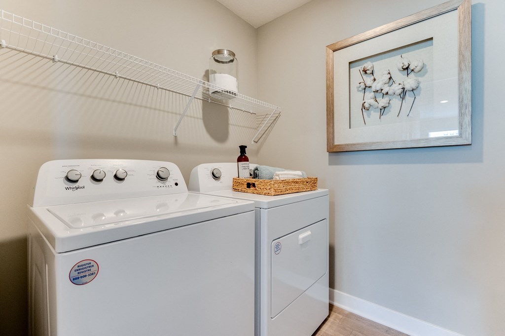 a washer and dryer in a laundry room with a painting on the wall