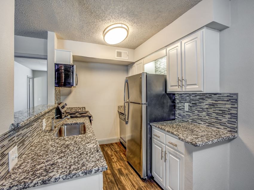 Apartments in Dallas-Paxton at Lake Highlands Kitchen with Matching Appliances, Gorgeous Tile Backsplash, and Hardwood Floors - Photo Gallery 1