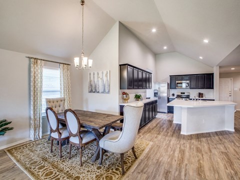 a dining room and kitchen with a table and chairs