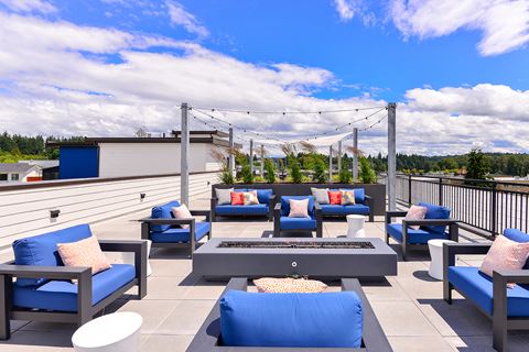 Apartments for Rent in Bothell - Community Rooftop Lounge Area with Plush Seating, Tables, and Aesthetic Lighting