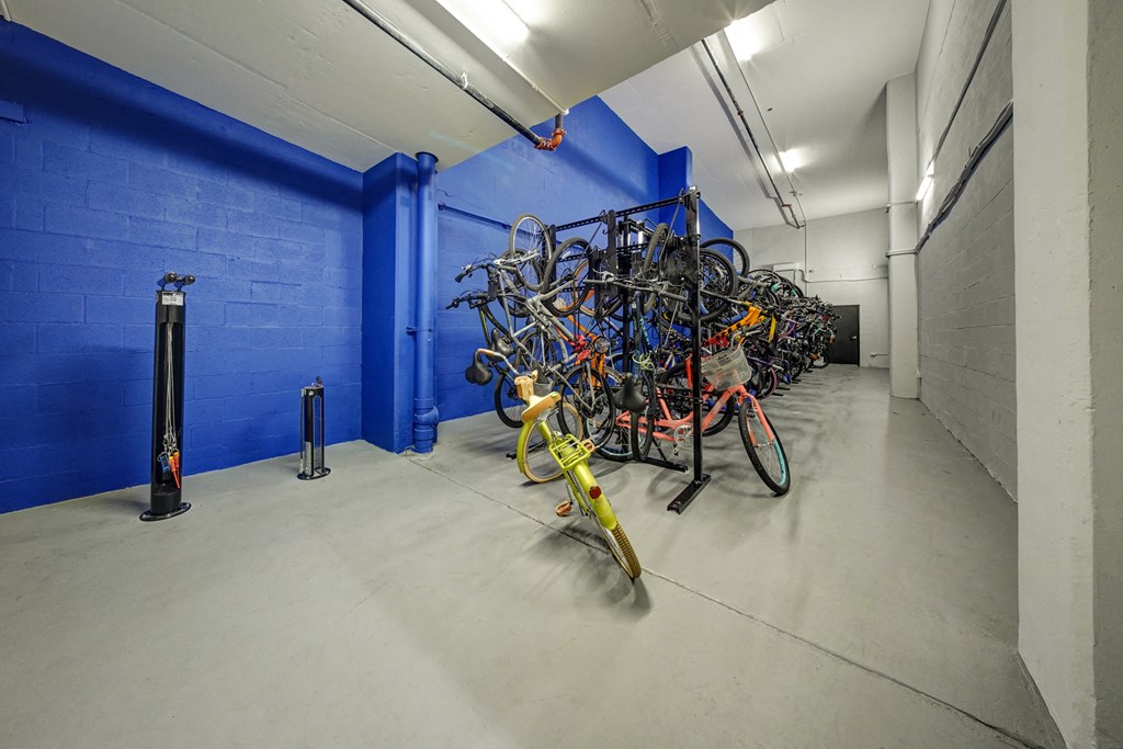 a bunch of bikes in a room with a blue wall