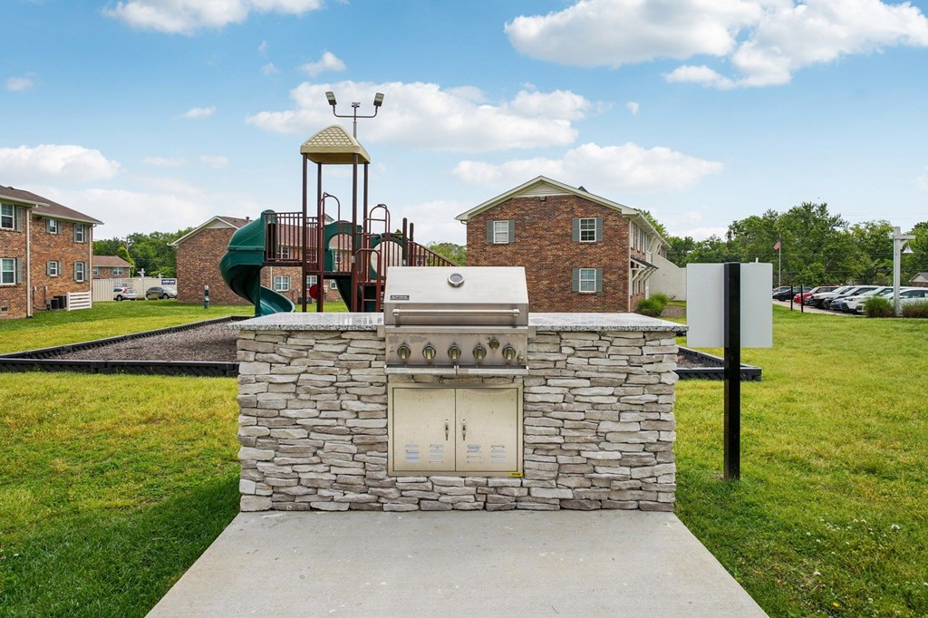 Outdoor grill and playground at a residential community.