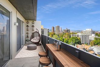 a balcony with a view of the city and a wooden table and chairs