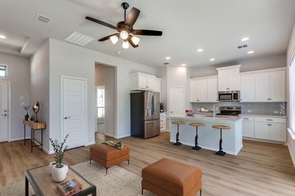 A modern kitchen with a ceiling fan and a dining table with four chairs.