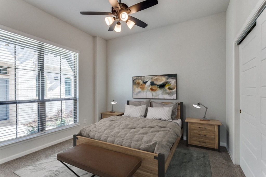 A bedroom with a large bed and a ceiling fan.