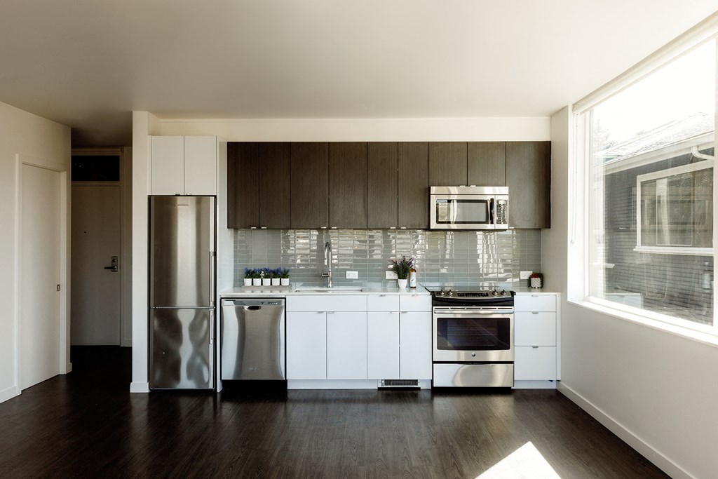 a kitchen with white cabinets and stainless steel appliances