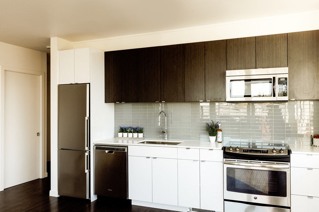 a kitchen with white cabinets and stainless steel appliances