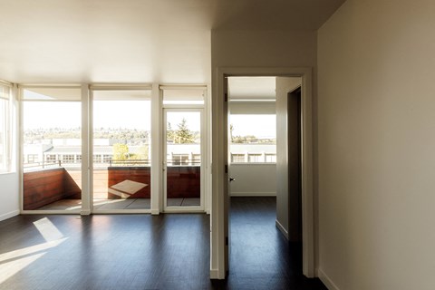 a living room with a view of a balcony and sliding glass doors