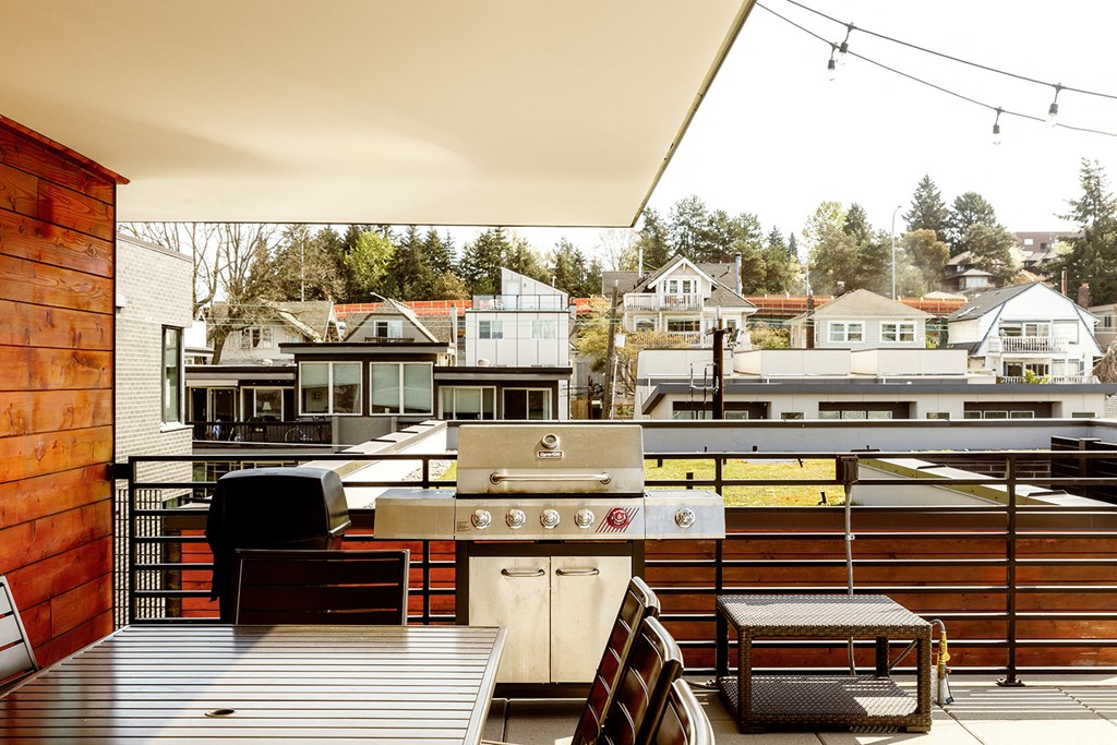 a kitchen with a grill and a table on a balcony