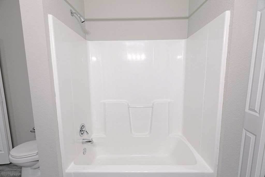 a white bathroom with a shower and a toilet