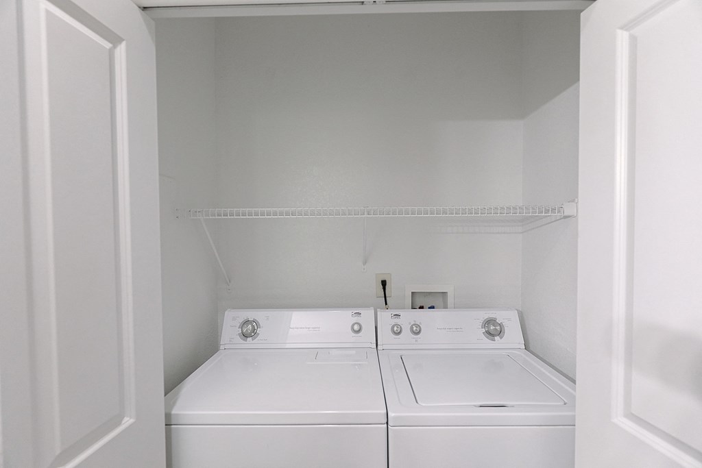 an empty laundry room with two washes and a dryer