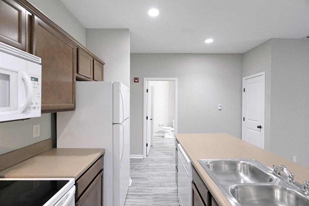 an empty kitchen with stainless steel appliances and a white refrigerator