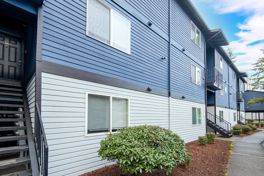 a side view of a blue and white building with a sidewalk