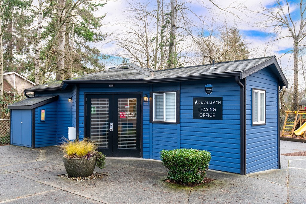 the outside of a blue building with a sign that reads aboriginal learning office