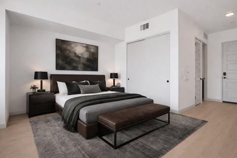 A modern bedroom with a large bed and a painting on the wall.