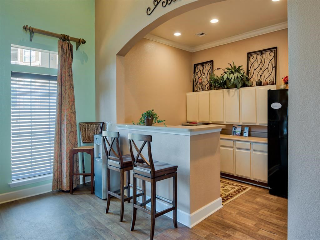 Clubhouse area with fridge, bar stools, counter and window with shades