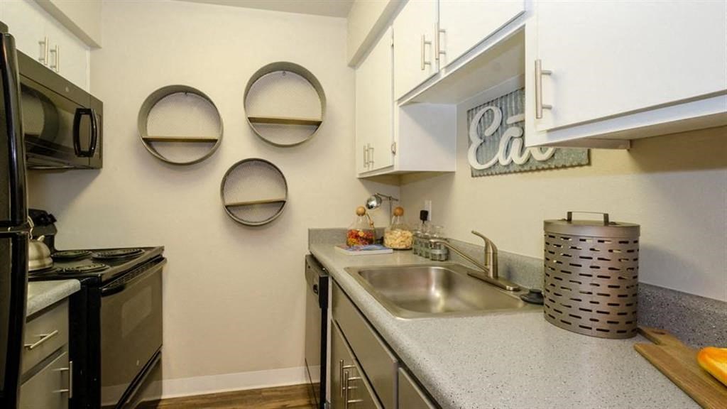 a kitchen with a sink a stove and a microwave