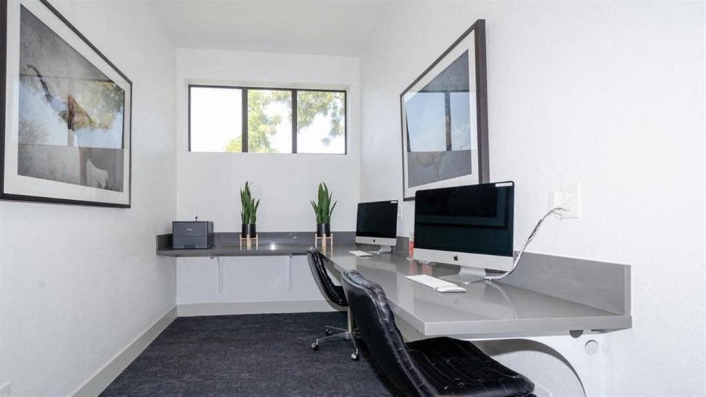 a desk with two computer monitors on top of it