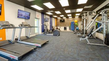 a gym with treadmills and other exercise equipment