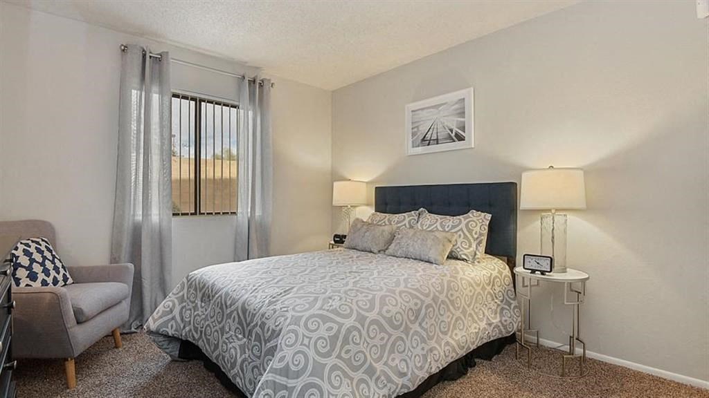One-Bedroom Apartments in Mesa, AZ - Mesa Station - Cozy Bedroom with Carpeted Flooring, Wall Art, Queen Bed, and Large Window