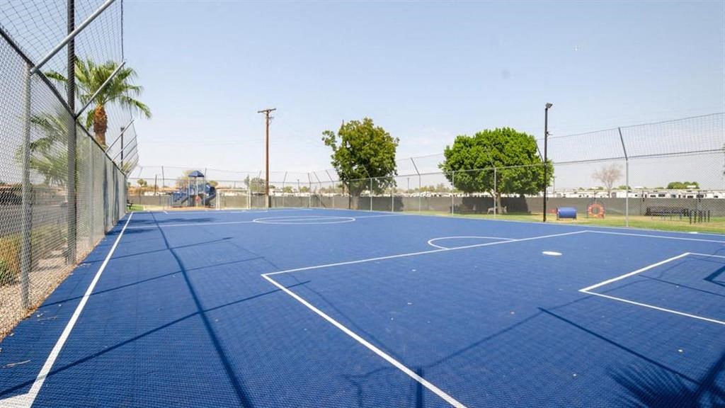 a blue tennis court with trees in the background