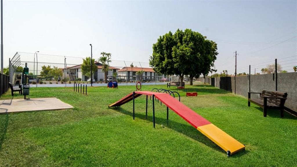 a park with a seesaw and benches on the grass