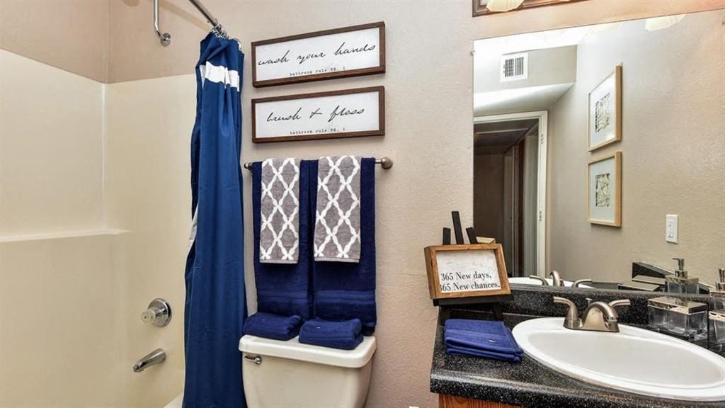 a bathroom with a toilet sink and a mirror