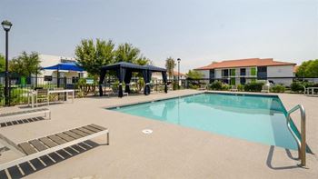 a resort style pool with lounge chairs and a gazebo