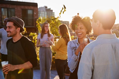 A group of people are standing outside on a sunny day.